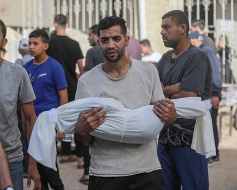 a man holding a child wrapped in a shroud