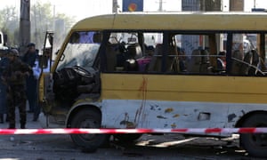 Afghan security forces inspect the damage of a minibus that was hit by a suicide attacker in Kabul.