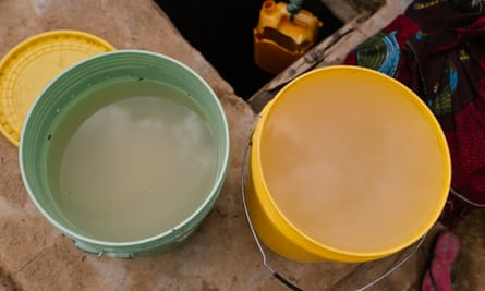 Buckets of water from a privately owned shallow well on the edge of Nyarugusu