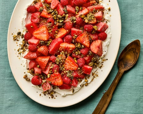 Sliced strawberries and raspberries arranged on labneh, sprinkled with pistachio dukkah
