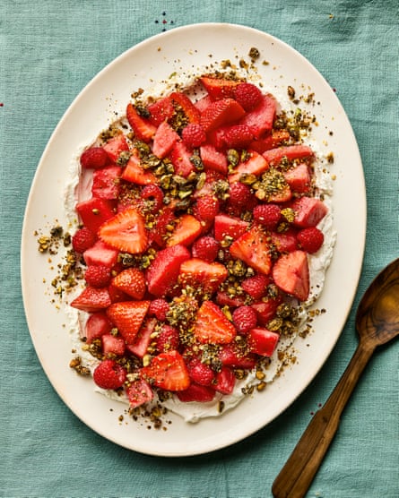 Fruit salad with watermelon, berries, rose and pistachio dukkah on a plate