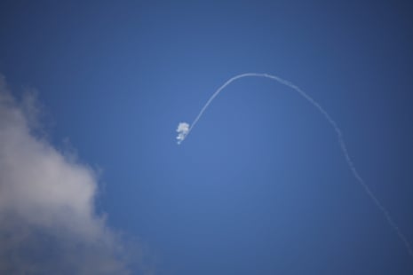 Объект проносится по голубому небу, оставляя за собой облачный след.