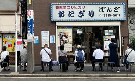 Customers wait on chairs outside the shop