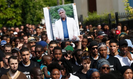 People holding a picture of Adama Traoré at a march in 2016.
