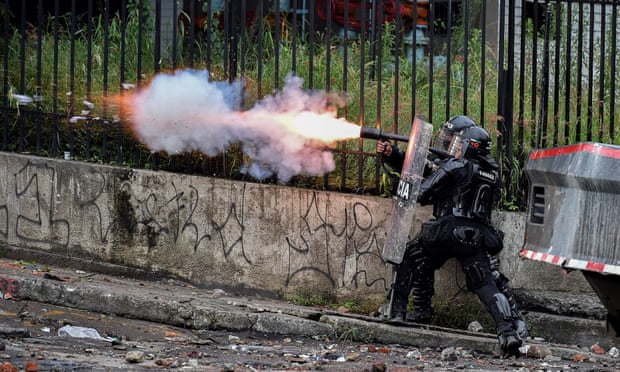 Riot police officers fire teargas at demonstrators in Cali on 10 May.