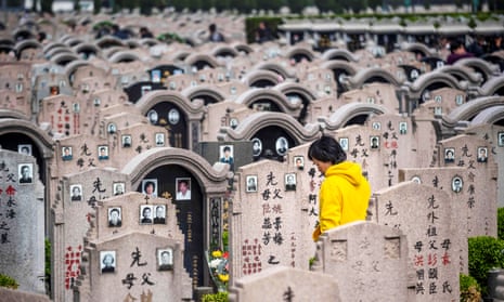 A woman decorates a grave at a cemetery in Shanghai