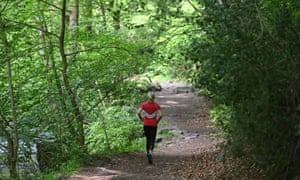 a woman running in a forest