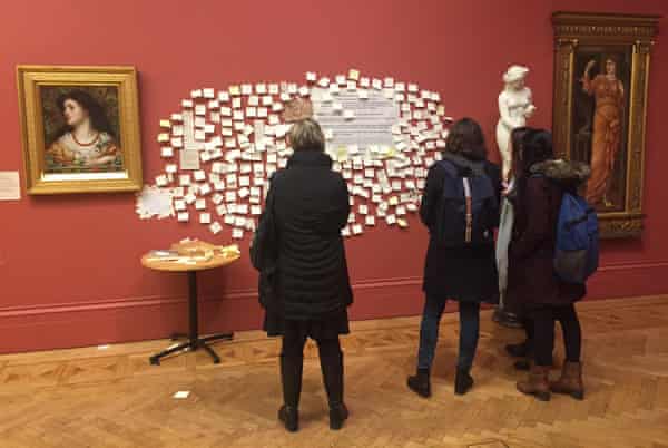 Visitors read the posted notes about the depiction of women in the gallery attached to the wall in place of the Waterhouse painting Boyce removed.