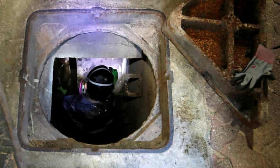 A protester tries to escape through a manhole into a sewage tunnel inside the Polytechnic University campus.