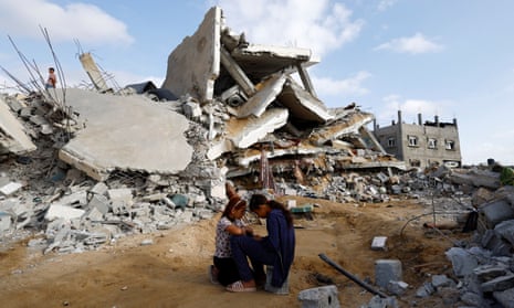 Palestinian children sit next to the site of an Israeli strike on a house in Rafah