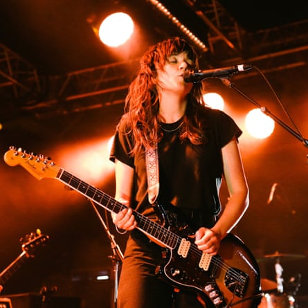 Courtney Barnett chantant directement dans le micro et tenant une guitare électrique