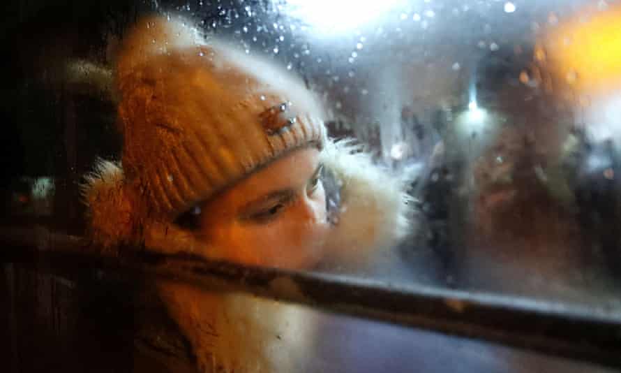 A person sits inside a bus arranged to evacuate local residents in Donetsk
