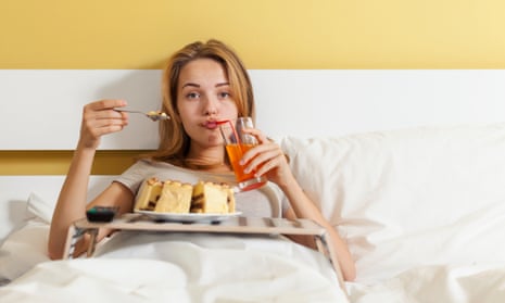 روز پرخور، دختر نوجوان در حال خوردن كيك و نوشيدني نوشابه دختر نوجوان در حال نوشيدن نوشابه، خوردن كيك در رختخواب و تماشاي تلويزيون