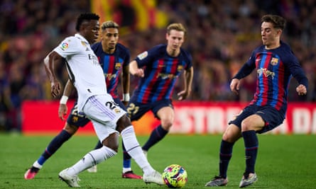 Vinícius Júnior of Real Madrid up against three Barcelona players.