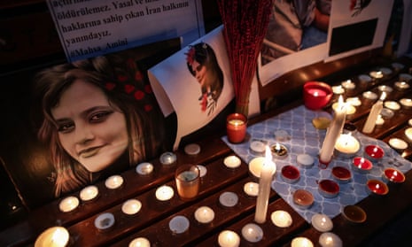 Iranian people light candles and display pictures of Mahsa Amini during a protest in Istanbul in September