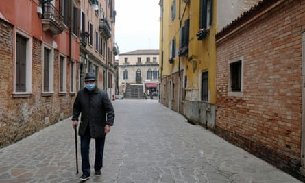 An elderly man walks down a deserted street in Venice