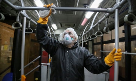 A Tehran municipality worker cleaning a bus