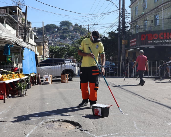 Brazilians paint streets to celebrate World Cup after deadly police raid: ‘Why not transform this place?’