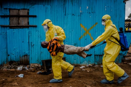 Medical workers in yellow protective clothing and masks carry a boy suspected of having Ebola, into a treatment centre in Monrovia, Liberia, September 5 2014