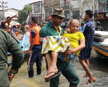 Rescue personnel rescue a woman from a flood-affected area in a suburb of Colombo