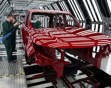 Staff check the paintwork on Range Rover bodies as they pass through the paint shop at Jaguar Land Rover’s factory in Solihull