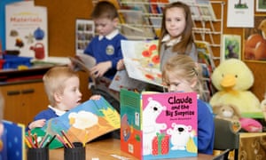 Children read at tables in a primary school classroom
