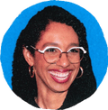 woman in glasses smiling and looking to side against blue background