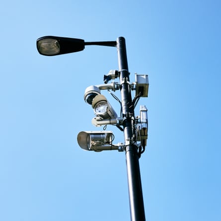 Outdoor security cameras in inner cityUK, London, looking up at a lamp post with security cameras against clear blue sky