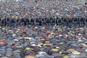 Riot police stand guard as Muslims gather to perform Eid al-Fitr prayer in Moscow, Russia