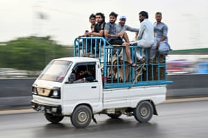 people sitting on top of a van with cattle in it
