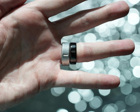 The Oura Ring 5 in black next to the Ring 4 in brushed silver.
