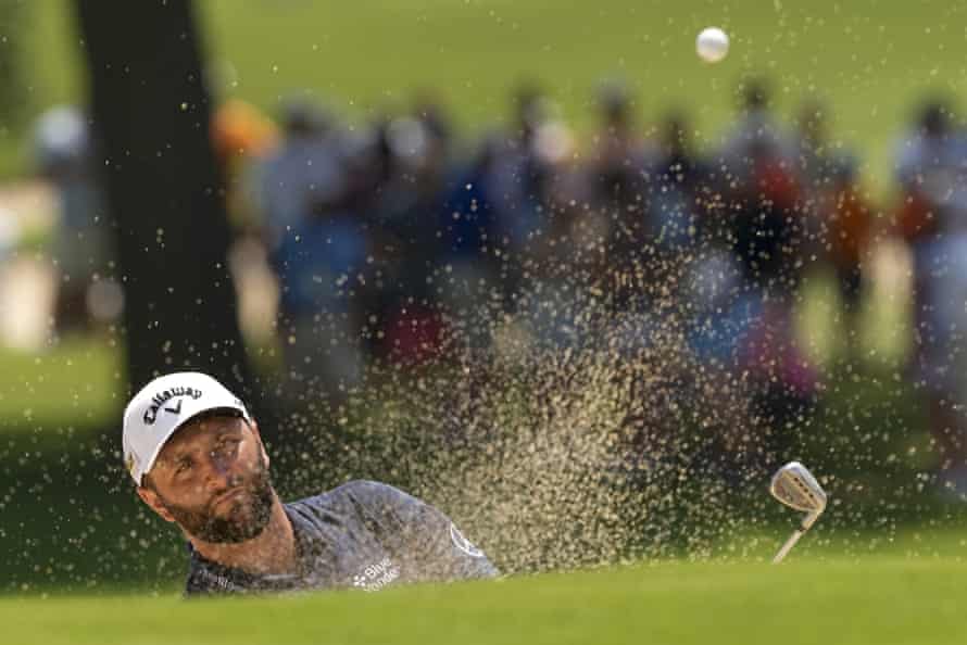 Jon Rahm plays from the bunker on the first.