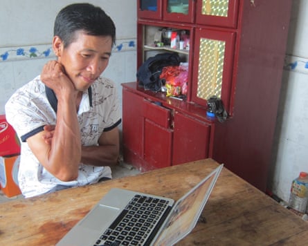 A Chinese man looking at a laptop screen