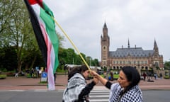 Two demonstrators wave the Palestinian flag  outside the International Court of Justice at The Hague.