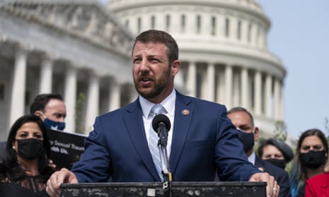 Markwayne Mullin stands at a podium surrounded by supporters with the white dome of the US Capitol building in the background.