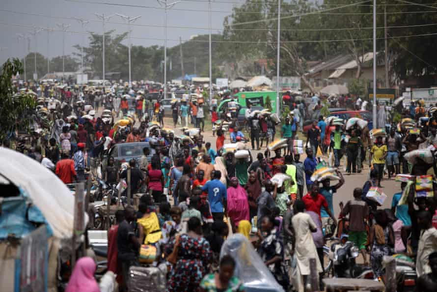 People carry off bags of food after a warehouse was looted during a Covid lockdown last October.