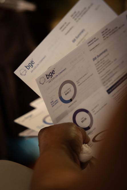 close-up of a person shuffling through utility bills labeled BGE