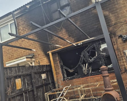 The back of the house, showing charred brickwork on the upper floor and the burned-out back window.
