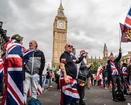 People wearing union jack flags gather with Big Ben in the background