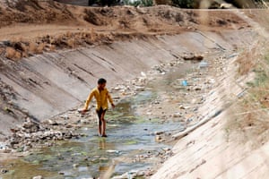 An boy walks through a dried up irrigation dyke in the Iraqi village of Sayyed Dakhil where drought is threatening agriculture and livelihoods.