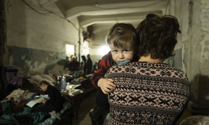 A woman holds a child in an improvised bomb shelter in Mariupol, Ukraine, Monday, March 7, 2022.