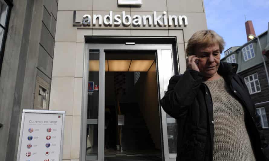 A woman leaves a branch of Iceland’s second largest bank, Landsbanki