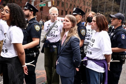 police officers hold detained people in a line