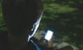 Young man looking at mobile phone in the dark