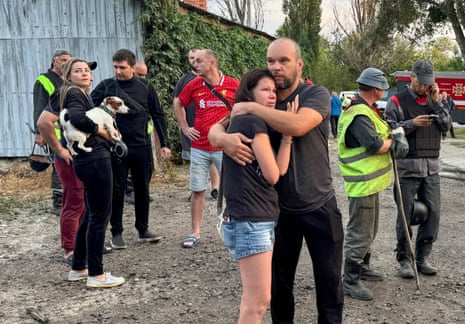 Residents react at the site of their apartment building hit by a Russian drone strike in Kharkiv.