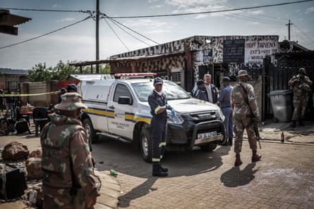 Members of South Africa's forensic pathology service and armed forces personnel inspect the scene of the shooting at the bar in Wedela.