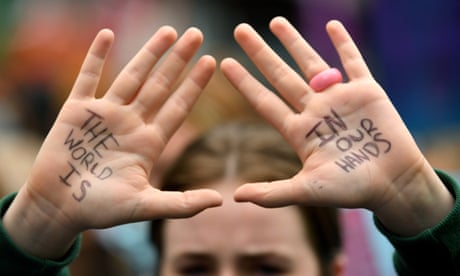 A school student's hold their hands up with the words 'The world is in our hands' written ontheir palms at a School Strike 4 Life protest in Sydney on Friday, May 21, 2021