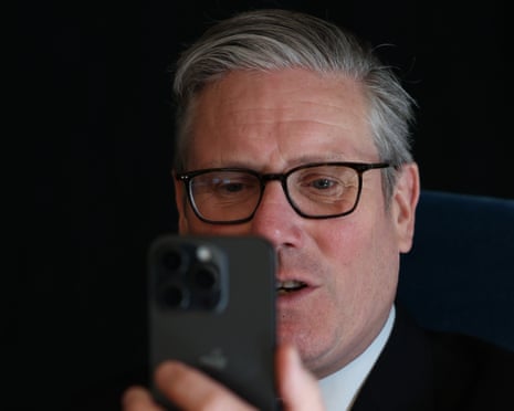 Keir Starmer holds up his mobile phone as he makes a call while attending a summit in Helsinki, Finland, in March