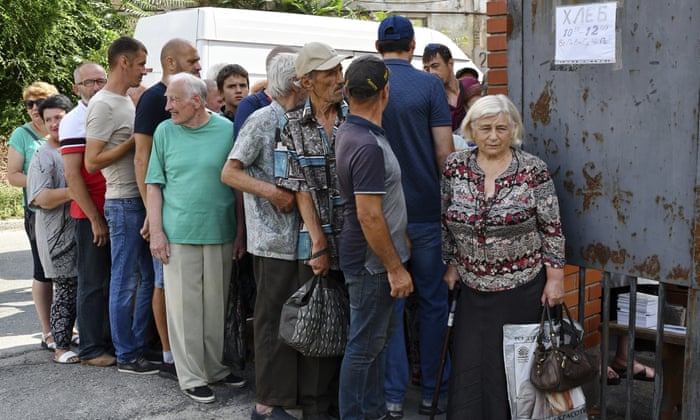 People line up to receive bread at a humanitarian aid distribution point in Zaporizhzhia.