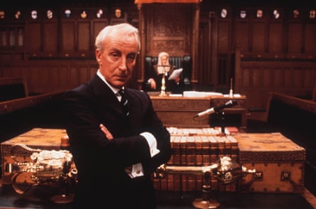 A grey haired man in suit in parliamentary room